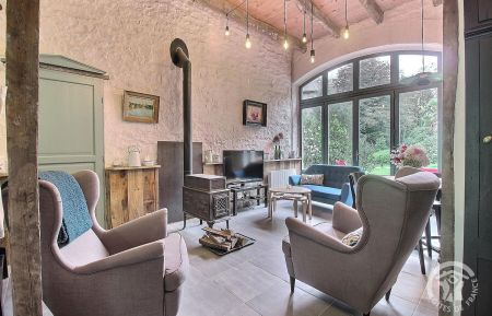 Le salon dans la Grange et son poêle à bois scandinave. Le poêle est un complément au chauffage installé. Gîte n°22G110219 Le Vieux-Marché - Côtes d'Armor - Le salon dans la Grange et son poêle à bois scandinave. Le poêle est un complément au chauffage installé.